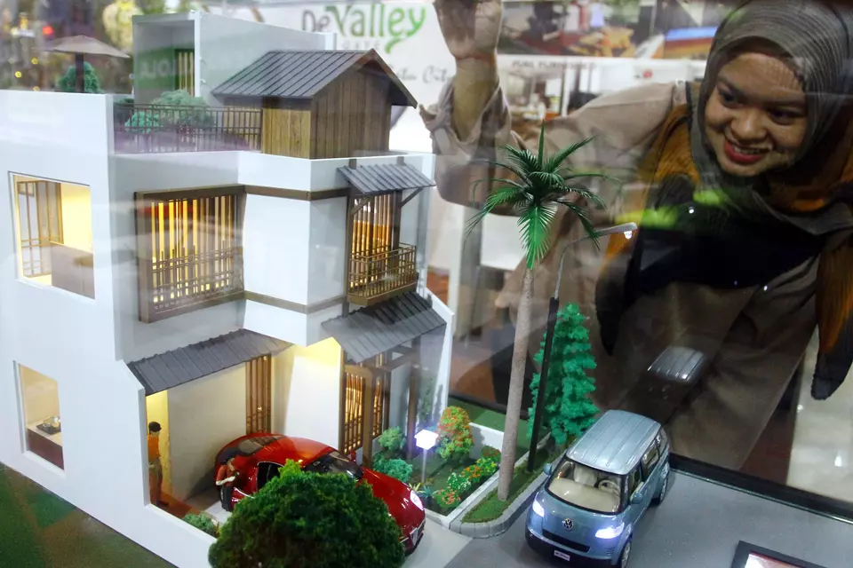 A woman takes a look at a housing model at a property exhibition in Malang on May 31, 2024. (Antara Photo/Ari Bowo Sucipto)