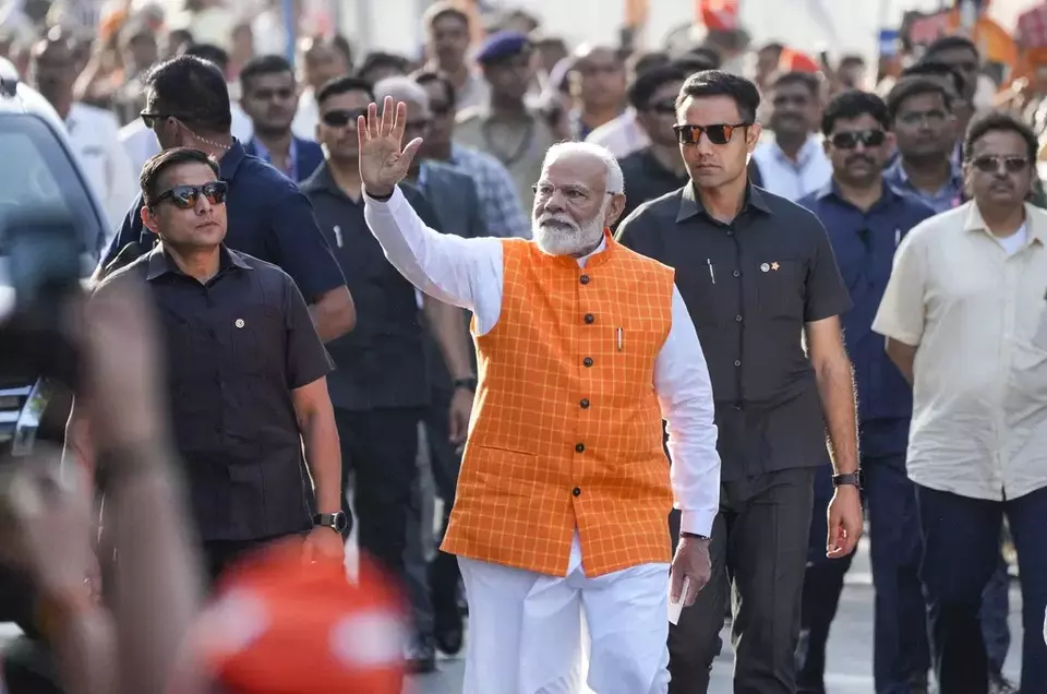 FILE- Indian Prime Minister Narendra Modi waves to people as he arrives to cast his vote during the third phase of national election, in Ahmedabad, India, May 7, 2024. (AP Photo/Ajit Solanki, File)