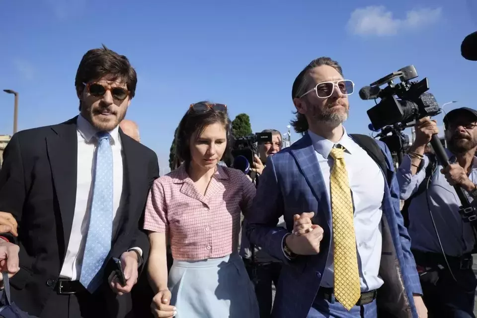 Amanda Knox arrives flanked by her husband Christopher Robinson, right, and her lawyer Luca Luparia Donati at the Florence courtroom in Florence, Italy, Wednesday, June 5, 2024. (AP Photo/Antonio Calanni)