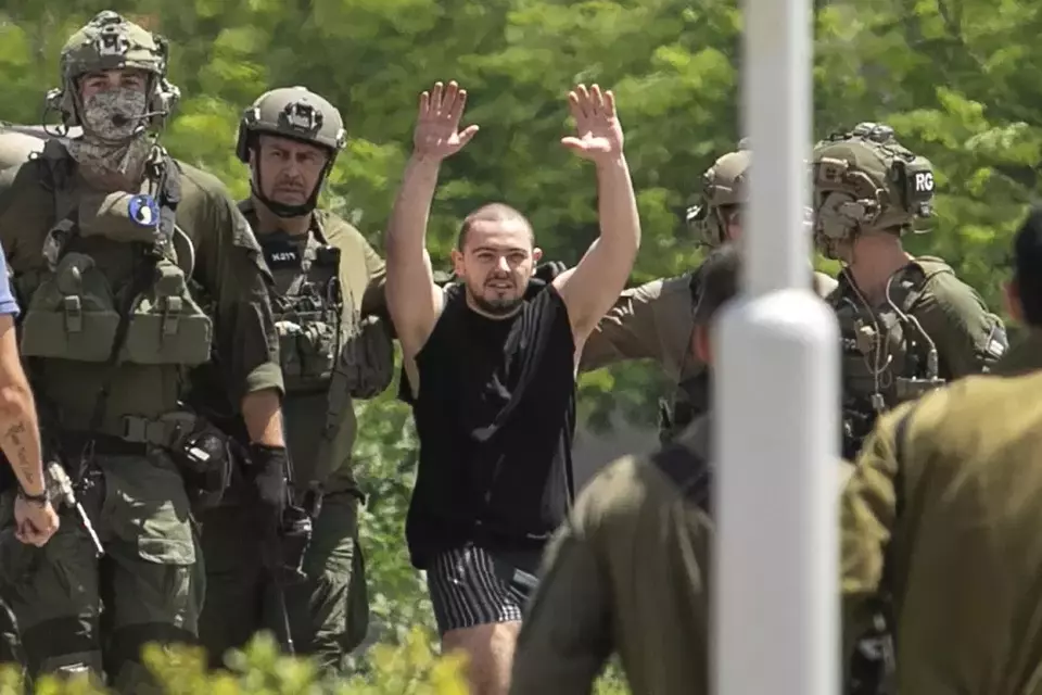 FILE - Almog Meir Jan, 22, kidnapped from Israel in a Hamas-led attack on Oct. 7, 2023, raises his hands after arriving by helicopter to the Sheba Medical Center in Ramat Gan, Israel, Saturday, June 8, 2024. Israel says it has rescued four hostages in Gaza who were kidnapped in a Hamas-led attack on Oct. 7. (AP Photo/Tomer Appelbaum)