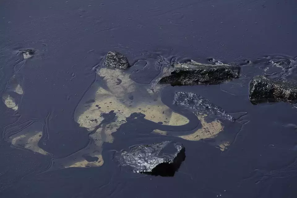 An oil spill is seen along Sentosa's Tanjong Beach area in Singapore, Sunday, June 16, 2024. (AP Photo/Suhaimi Abdullah)