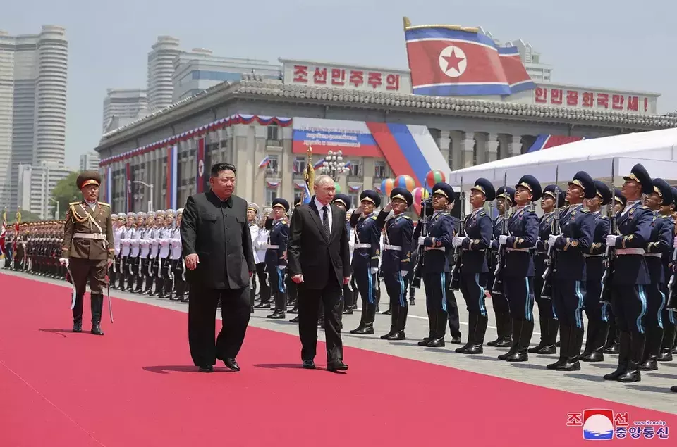 In this photo provided Thursday, June 20, 2024, by the North Korean government, Russian President Vladimir Putin, center, and North Korea