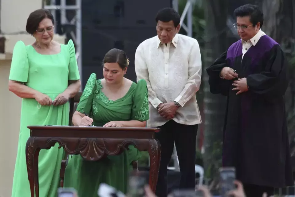 FILE - Sara Duterte, daughter of outgoing populist president of the Philippines, signs documents during her oath taking as vice president in her hometown in Davao city, southern Philippines, June 19, 2022. (AP Photo/Manman Dejeto, File)