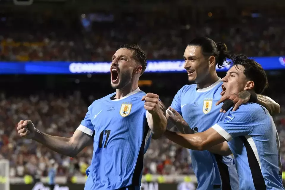 Matias Vina, left, celebrates the opening goal for Uruguay scored by teammate Mathias Olivera during a Copa America Group C soccer match against the United States in Kansas City, Monday, July 1, 2024. (AP Photo/Reed Hoffman)