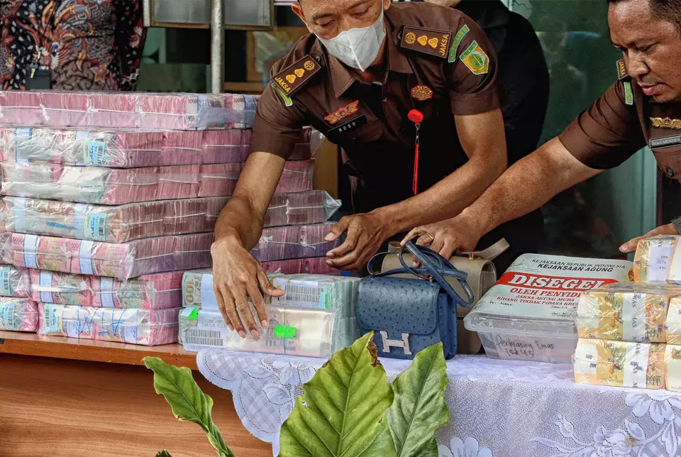 South Jakarta prosecutors pile up banknotes in several currencies and luxury bags during a news conference at their office in South Jakarta, Monday, July 22, 2024. The banknotes will be used as evidence Harvey Moeis and Helena Lim who have been accused of corruption. (B-Universe Photo/Joanito De Saojoao)