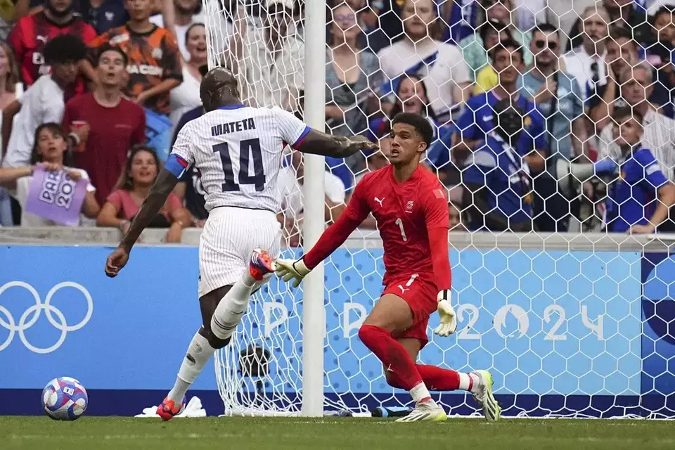 Jean-Philippe Mateta, left, shoots the ball to score a goal for France during the Group A soccer match between New Zealand and France at the Velodrome stadium, during the 2024 Summer Olympics, Tuesday, July 30, 2024, in Marseille, France. (AP Photo/Daniel Cole)