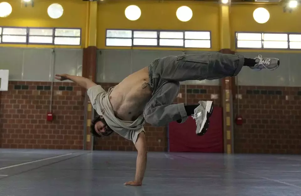 Alexandre Sazy breakdances in a gymnasium at the 2024 Paris Olympics, Tuesday, July 30, 2024, in Paris, France. (AP Photo/Yasin Dar)