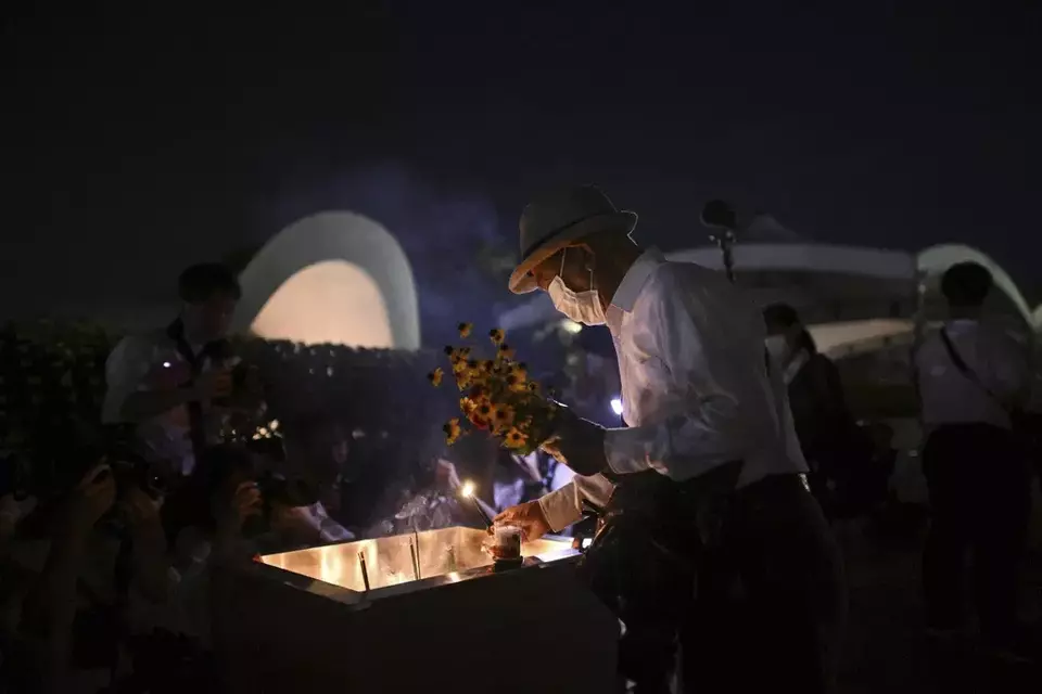 A man places incense in front of the cenotaph dedicated to the victims of the atomic bombing, early in the morning before an annual ceremony marking the 79th anniversary of the world's first atomic bombing at the Peace Memorial Park in Hiroshima, western Japan, Tuesday, Aug. 6, 2024. (Yu Nakajima/Kyodo News via AP)
