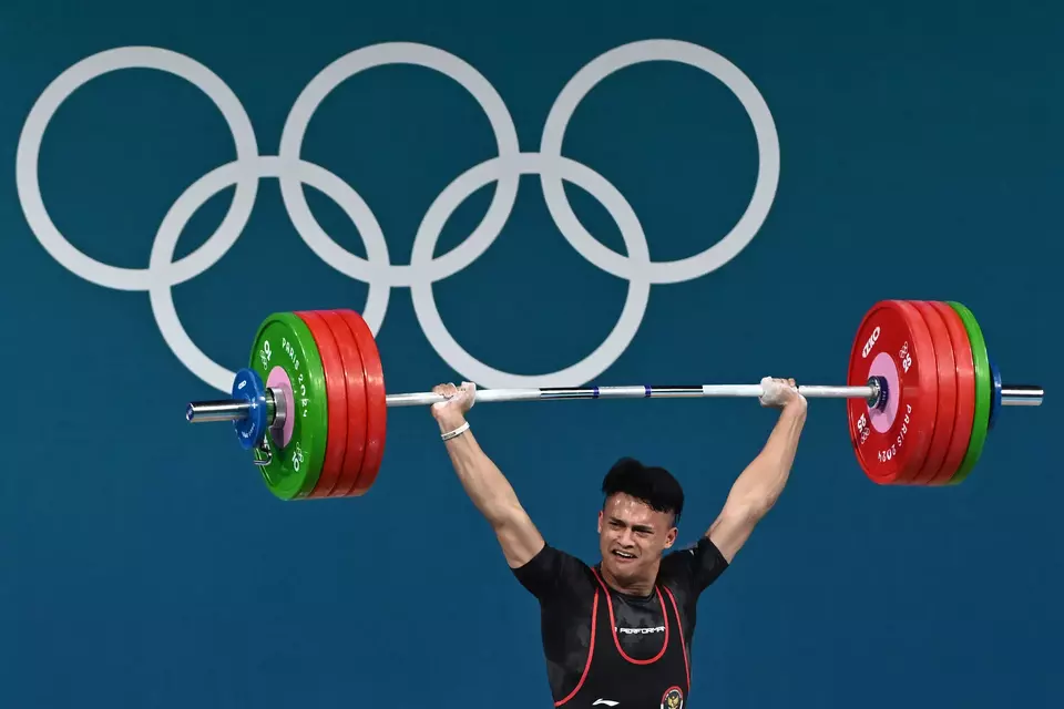 Indonesian weightlifter Rizki Juniansyah completes the clean and jerk lift in men's 73kg at the Paris Olympics, Thursday, Aug. 8, 2024. (Antara Photo/Wahyu Putro)