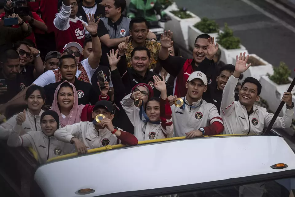 Olympics medalists Veddriq Leonardo, Rizki Juniansyah, and Gregoria Mariska Tunjung alongside fellow athletes go on a parade on their way to the State Palace in Jakarta on August 15, 2024. (Antara Photo/Aprillio Akbar)