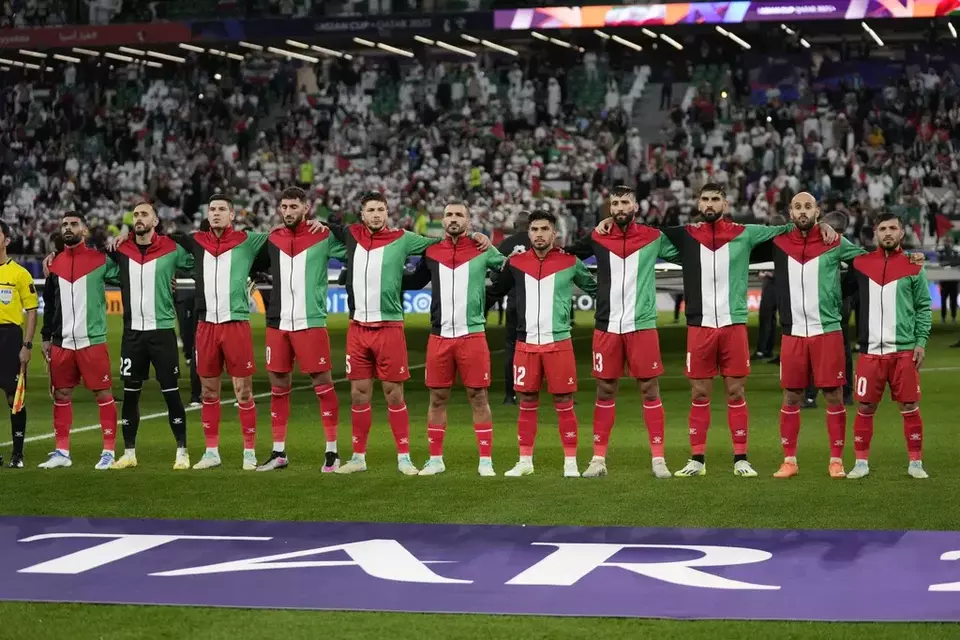 Palestinian team stand for the national anthem ahead of the Asian Cup Group C soccer match between Iran and Palestine at the Education City Stadium in Al Rayyan, Qatar, Jan. 14, 2024. (AP Photo/Aijaz Rahi)