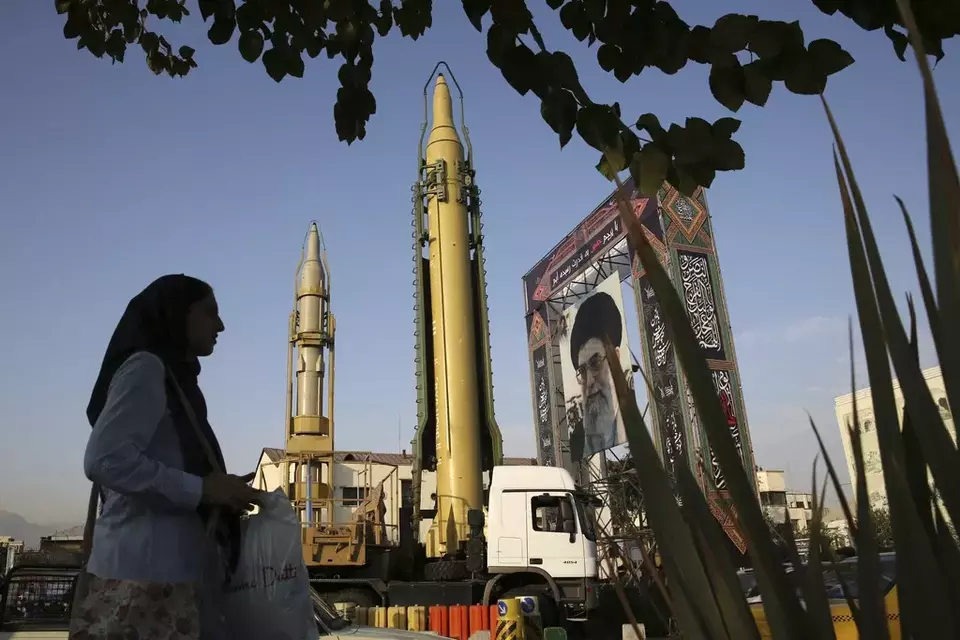 FILE - A Ghadr-H missile, center, a solid-fuel surface-to-surface Sejjil missile and a portrait of the Supreme Leader Ayatollah Ali Khamenei are on display for the annual Defense Week at Baharestan Sq. in Tehran, Iran, Sept. 24, 2017. (AP Photo/Vahid Salemi, File)