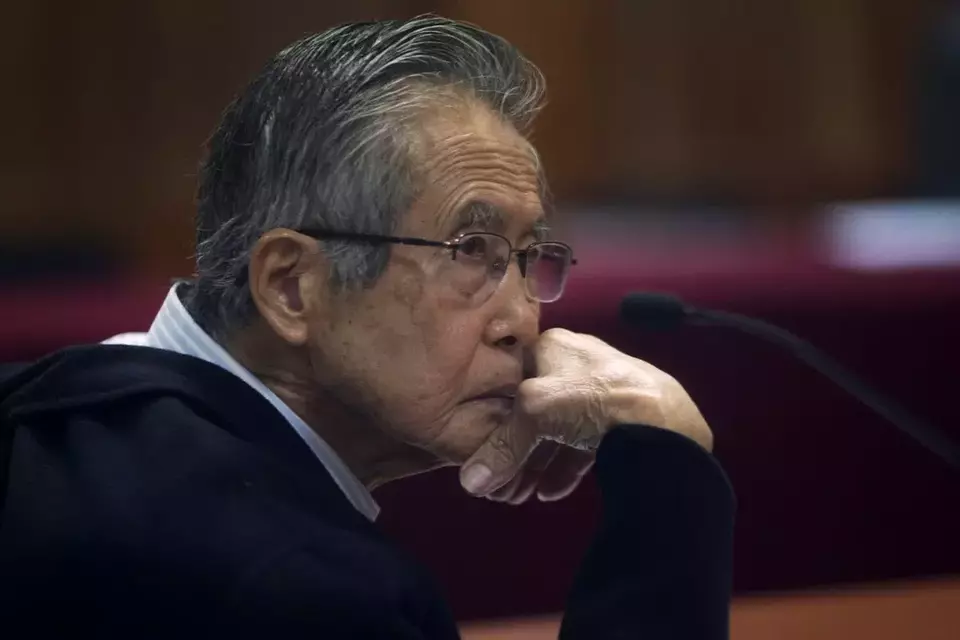 FILE - Alberto Fujimori, photographed through a glass window, attends his trial at a police base on the outskirts of Lima, Peru, June 28, 2016. (AP Photo/Martin Mejia, File)