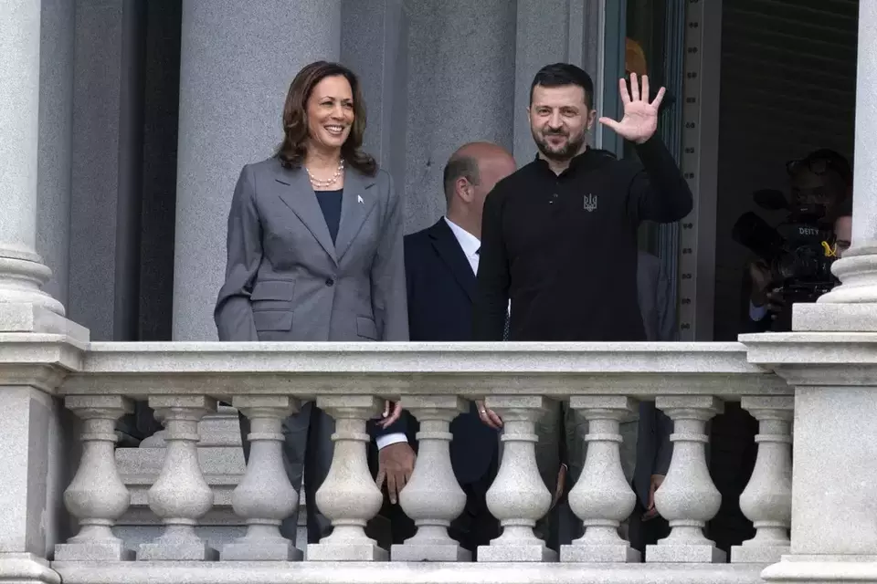 Vice President Kamala Harris accompanied by Ukrainian President Volodymyr Zelensky, waves from the balcony of the Eisenhower Executive Office Building on the White House complex in Washington, Thursday, Sept. 26, 2024. (AP Photo/Jose Luis Magana)