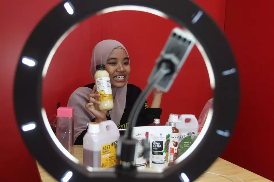 A small-scale entrepreneur goes on a livestream to promote her products at Pos Indonesia's office in Malang on Oct. 15, 2024. (Antara Photo/Ari Bowo Sucipto)
