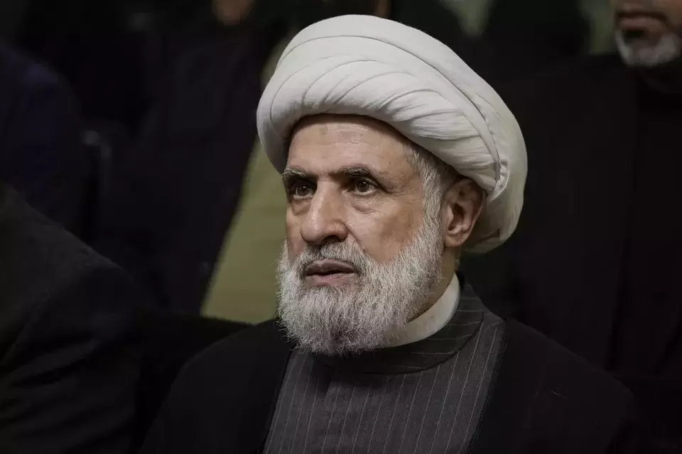 FILE - Hezbollah s deputy leader, Sheikh Naim Kassem, listens to a speech by then-leader Hassan Nasrallah on a screen in southern Beirut, Wednesday, June 19, 2024. (AP Photo/Bilal Hussein, File)