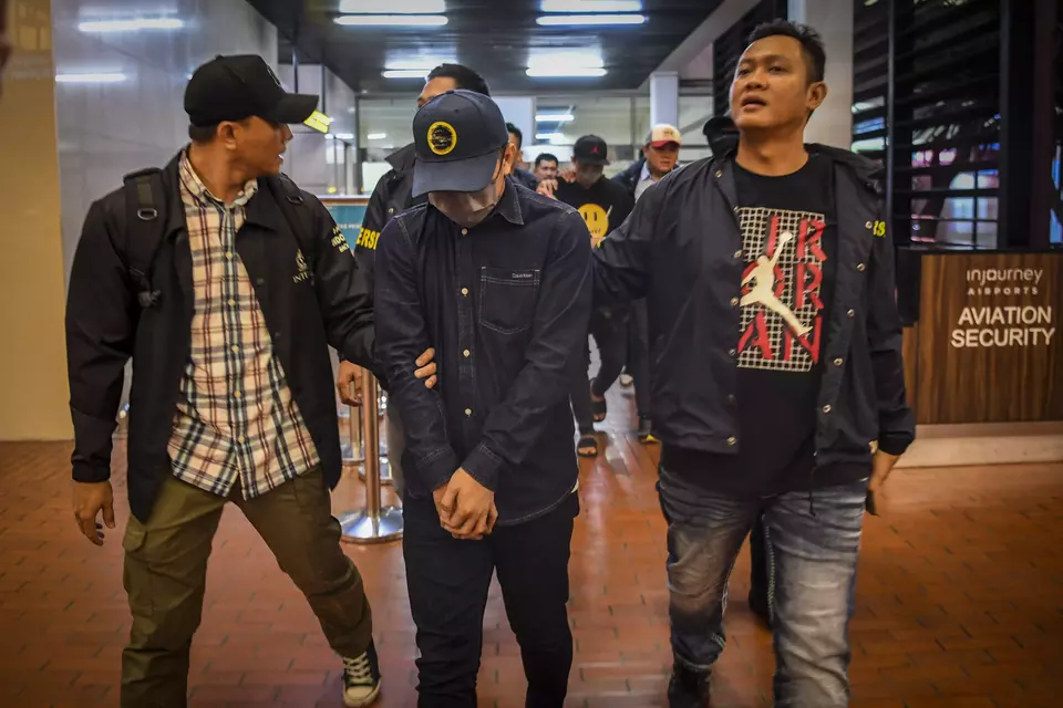 Police officers in plain clothes arrest two online gambling suspects at Soekarno Hatta Airport in Tangerang, Banten, Sunday, Nov. 10, 2024. (Antara Photo/Galih Pradipta)