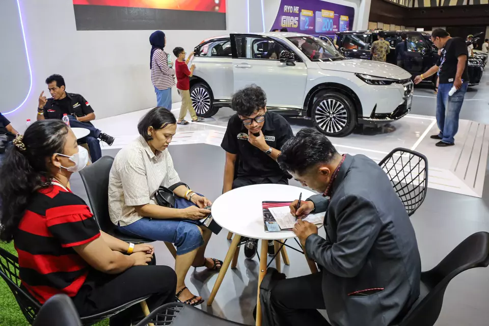 A car salesman talks to his customers at the Gaikindo Indonesia International Auto Show in Semarang on Oct. 27, 2024. (Antara Photo/Makna Zaezar)