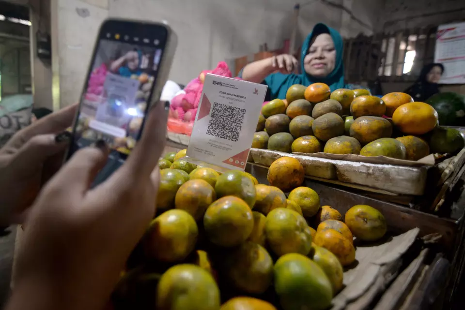 A customer scans the QRIS payment system code when shopping at a small-sized fruit vendor in Boyolali, Central Java on Dec. 2, 2024. (Antara Photo/Aloysius Jarot Nugroho)