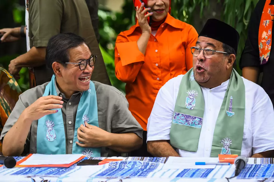 Jakarta gubernatorial candidate Pramono Anung, left, and his running mate Rano Karno laugh during a news conference in Cipete, Jakarta, Thursday, Nov. 28, 2024. (Antara Photo/Sulthony Hasanuddin)