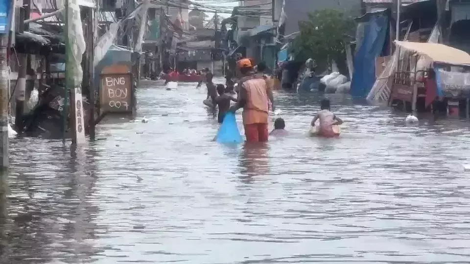 Residents navigate floodwaters in Muara Angke, North Jakarta, that have been submerged under 30–90 cm of seawater for four days. (Beritasatu.com/Gandhi Armansyah)