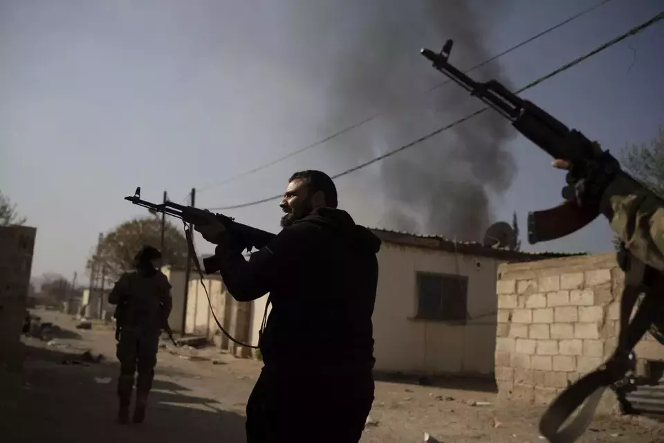 Syrian fighters aims their weapons in direction of suspected looters at a residential complex of former Bashar Assad's military officers at the village of Husseiniyeh, in the outskirts of Damascus, Syria, Sunday, Dec. 15, 2024. (AP Photo/Leo Correa)