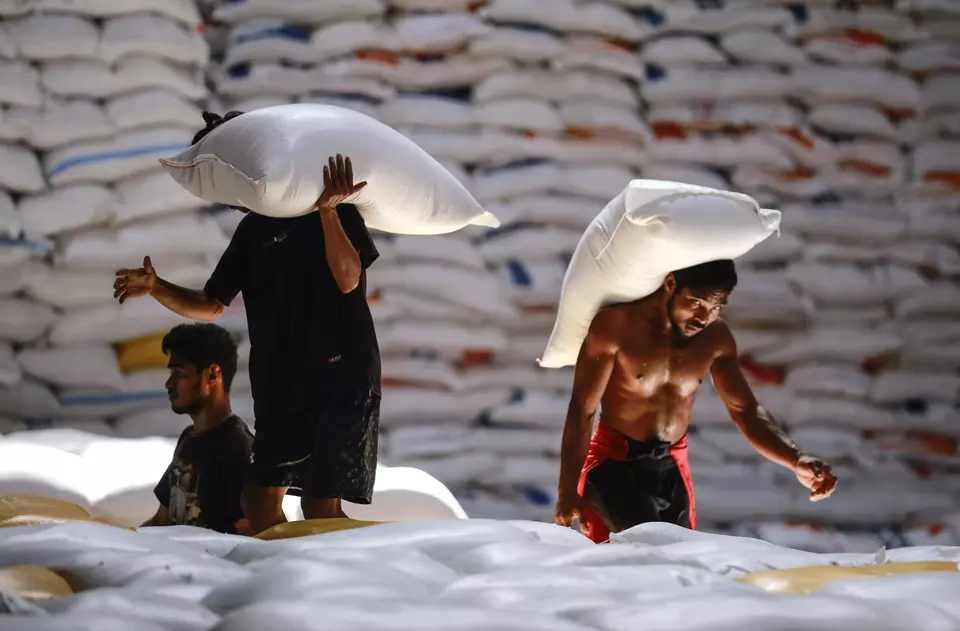 Workers carry rice bags at the logistics firm Bulog warehouse in North Maluku on Dec. 20, 2024. (Antara Photo/Andri Saputra)