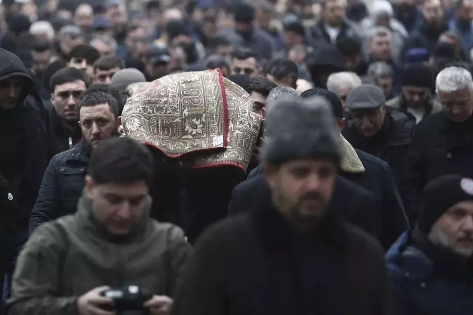 People attend the funeral of Mahammadali Eganov, 13, who died in the Azerbaijan Airlines Embraer 190 crash near Aktau airport, in Baku, Azerbaijan, Saturday, Dec. 28, 2024. (AP Photo)