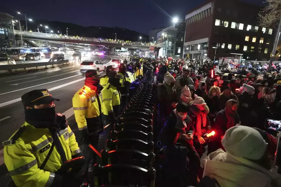 Supporters of impeached South Korean President Yoon Suk Yeol stage a rally to oppose a court having issued a warrant to detain Yoon, as police officers stand guard near the presidential residence in Seoul, South Korea, Friday, Jan. 3, 2025. (AP Photo/Lee Jin-man)