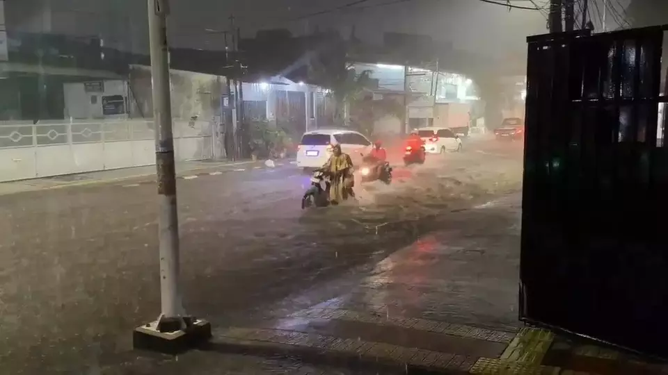 Heavy rainfall on Tuesday evening, Jan. 28, 2025, floods Plumpang Semper Road in North Jakarta, with water levels ranging from 15 to 30 centimeters. Several motorcyclists attempting to navigate the floodwaters have their engines stall. (Beritasatu.com/Gandhi Armansyah)