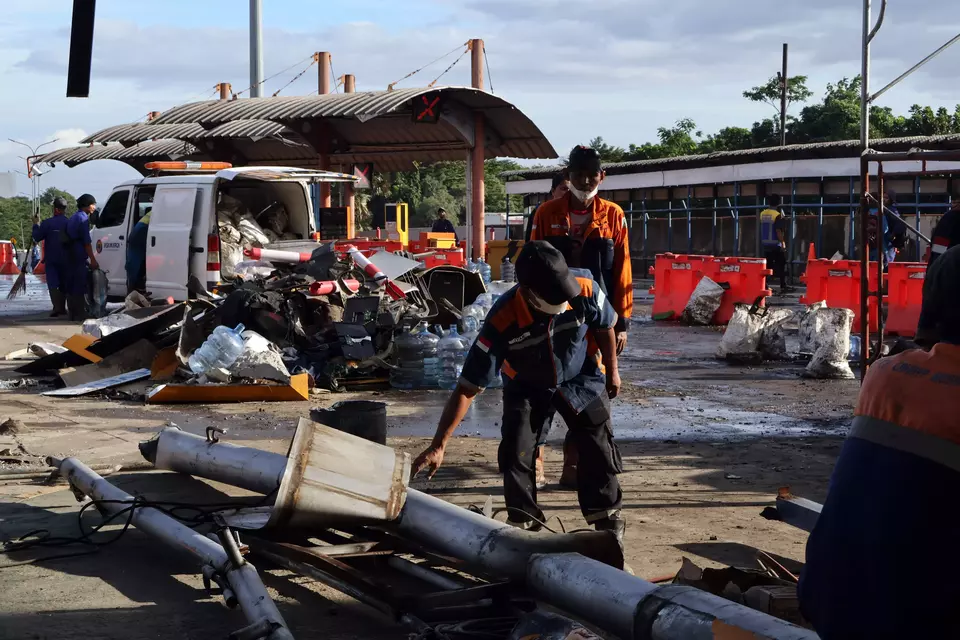 Officers clean the crash site at the Ciawi 2 Tollgate in Bogor on Feb. 5, 2025. (Antara Photo/Yulius Satria Wijaya)