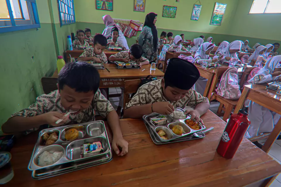Elementary school children eat the government-aided meals in Cibinong, Bogor, on Jan. 23, 2025. The meals are part of President Prabowo Subianto's school-feeding program. (Antara Photo/Yulius Satria Wijaya)