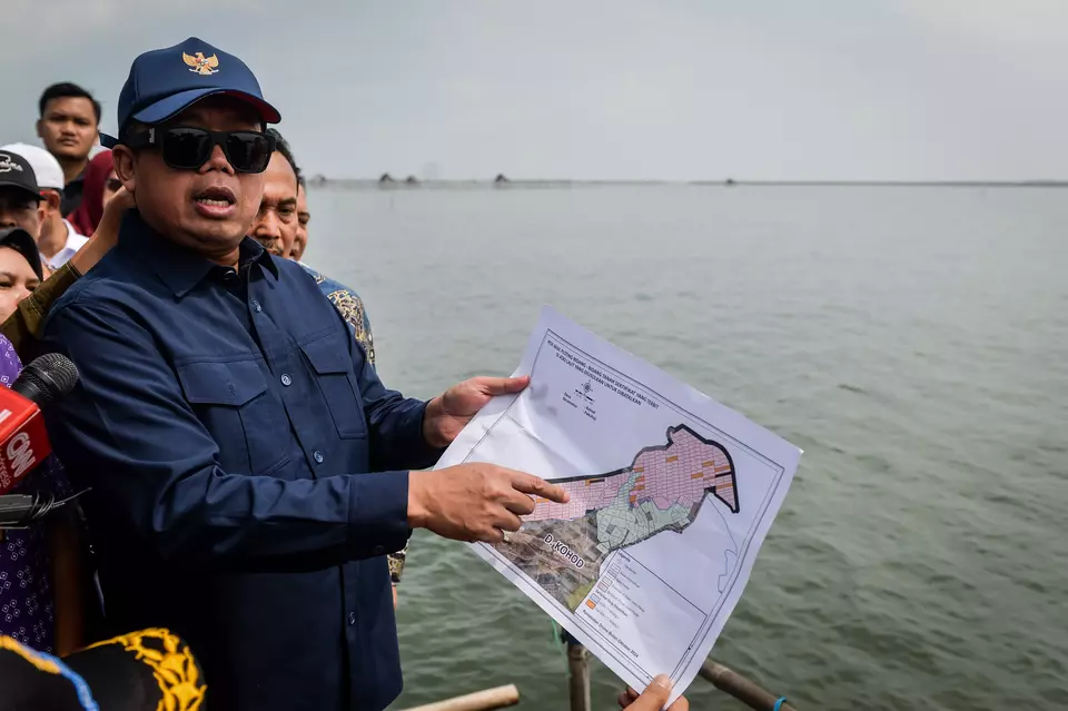 Agrarian and Spatial Planning Minister Nusron Wahid compares the water area in front of him with the land map in his hand during a visit to Kohod Village in Tangerang Regency, Banten, Friday, Jan. 24, 2025. (Antara Photo/Putra M. Akbar)