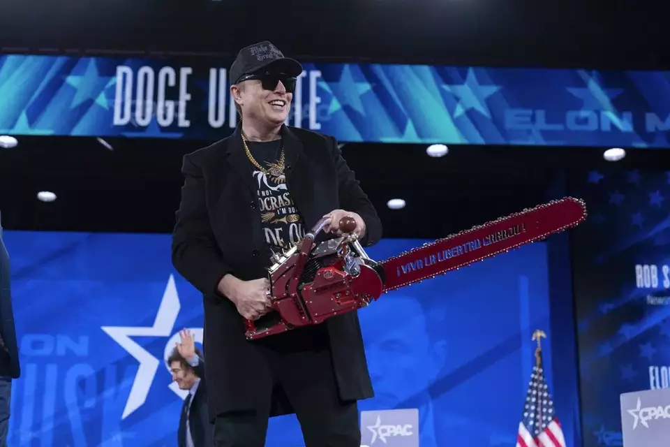 Elon Musk holds a chainsaw as he arrives to speak at the Conservative Political Action Conference, CPAC, at the Gaylord National Resort & Convention Center, Thursday, Feb. 20, 2025, in Oxon Hill, Md. (AP Photo/Jose Luis Magana)