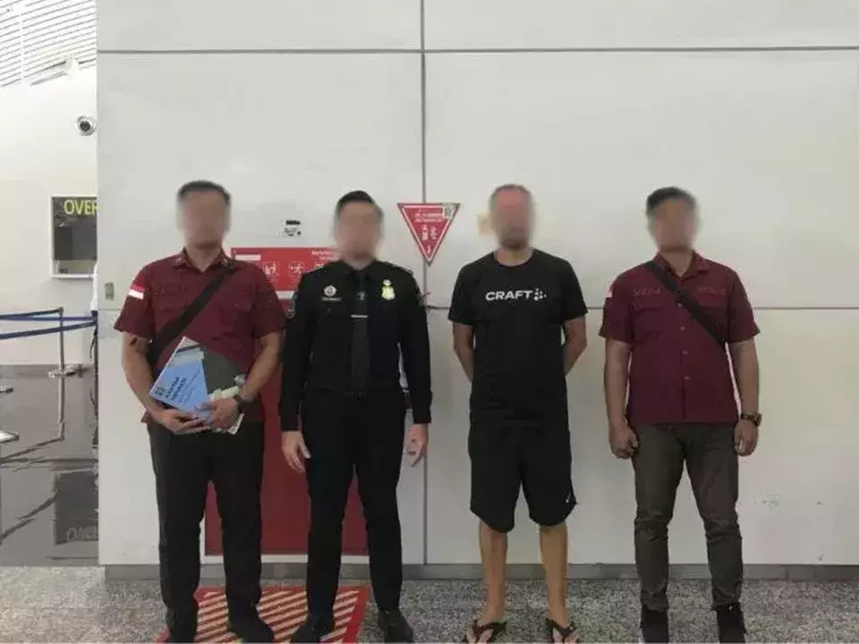 Indonesian immigration officers escort BG (third left), a 41-year-old Norwegian tourist, at Ngurah Rai International Airport on Feb. 20, 2025, before his deportation for violating Mount Agung hiking regulations. (Balipuspanews.com)