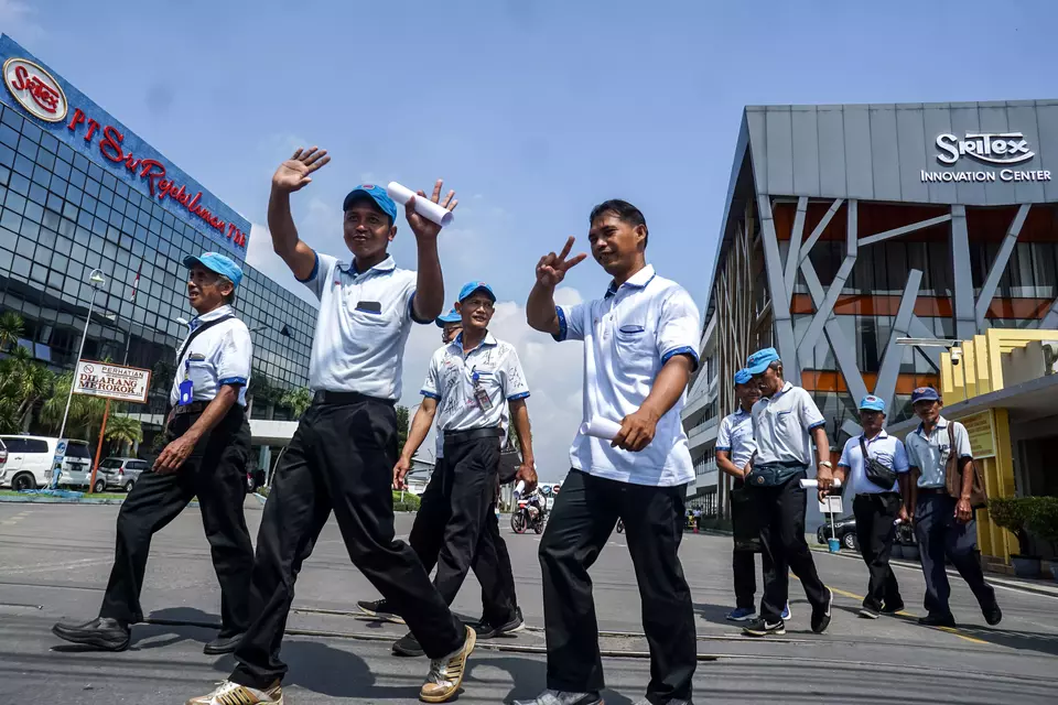 Workers walk out of a Sritex textile factory in Sukoharjo, Central Java, Friday, Feb. 28, 2025. Sritex has announced that it will cease all operations after the bankruptcy ruling. (Antara Photo/Mohammad Ayudha)