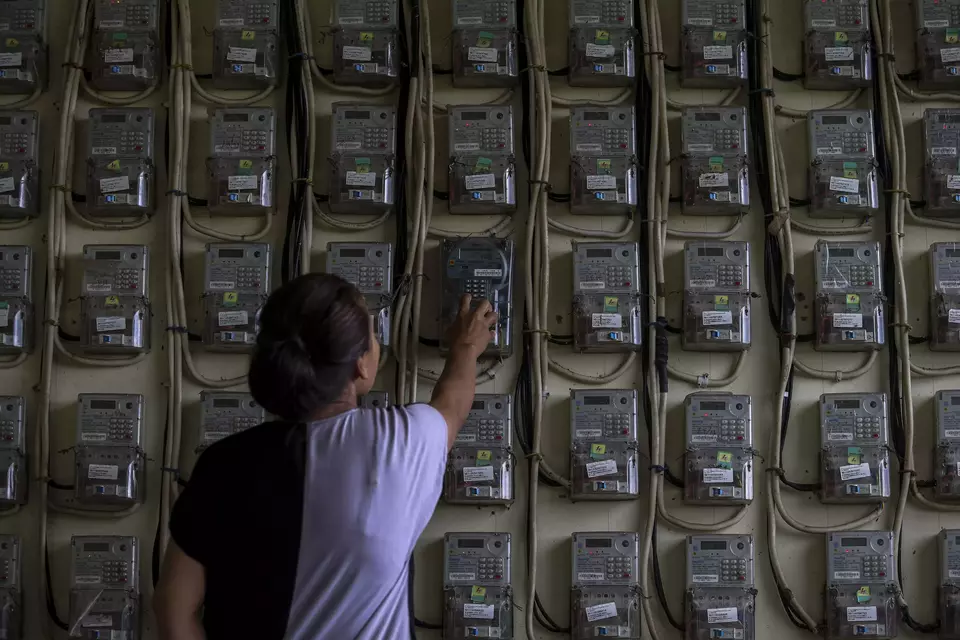 A woman checks on the electricity meters in a low-cost apartment building in Serang, Banten, on Feb. 3, 2025. (Antara Photo/Angga Budhiyanto)