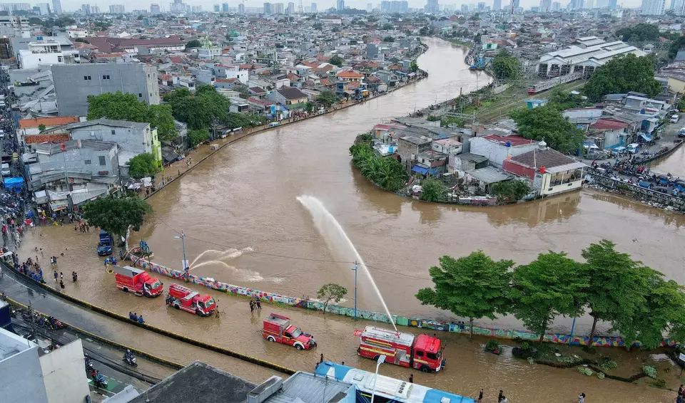 An aerial view shows firefighters using high-powered pumps to divert floodwater from West Jatinegara Street, East Jakarta, back into the Ciliwung River, on Tuesday, March 4, 2025. (B-Universe Photo/Joanito De Saojoao)