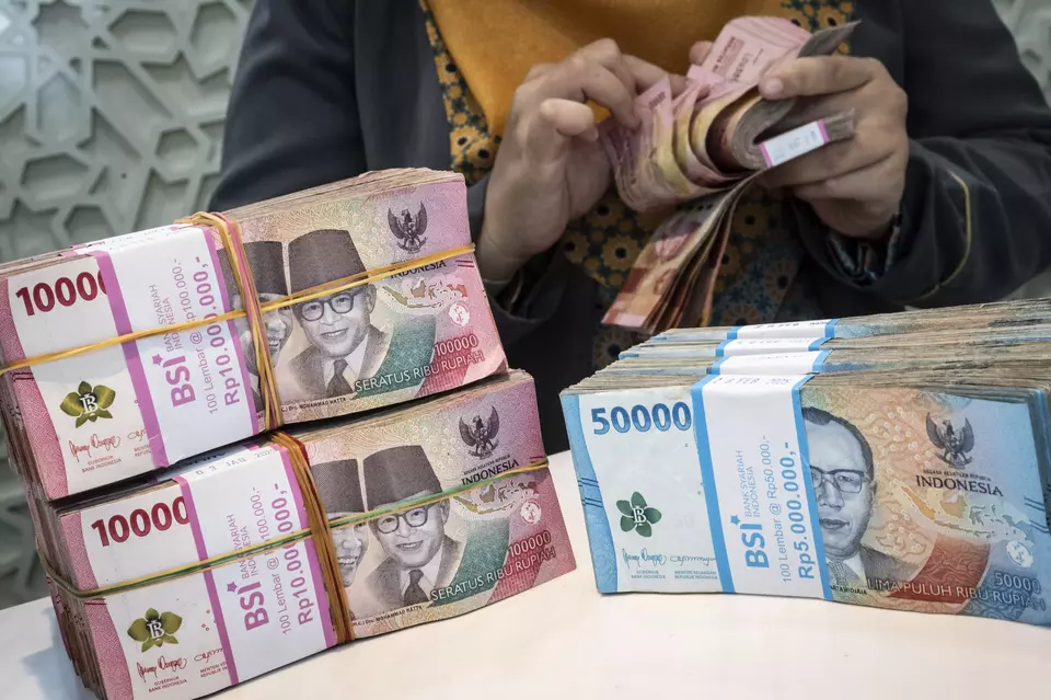 A bank teller counts cash at a Bank Syariah Indonesia (BSI) unit in Semarang on Feb. 27, 2025. (Antara Photo/Aprillio Akbar)