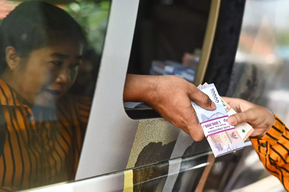 A woman exchanges her money with fresh banknotes at Bank Indonesia's mobile office in Denpasar on March 10, 2025. (Antara Photo/Fikri Yusuf)