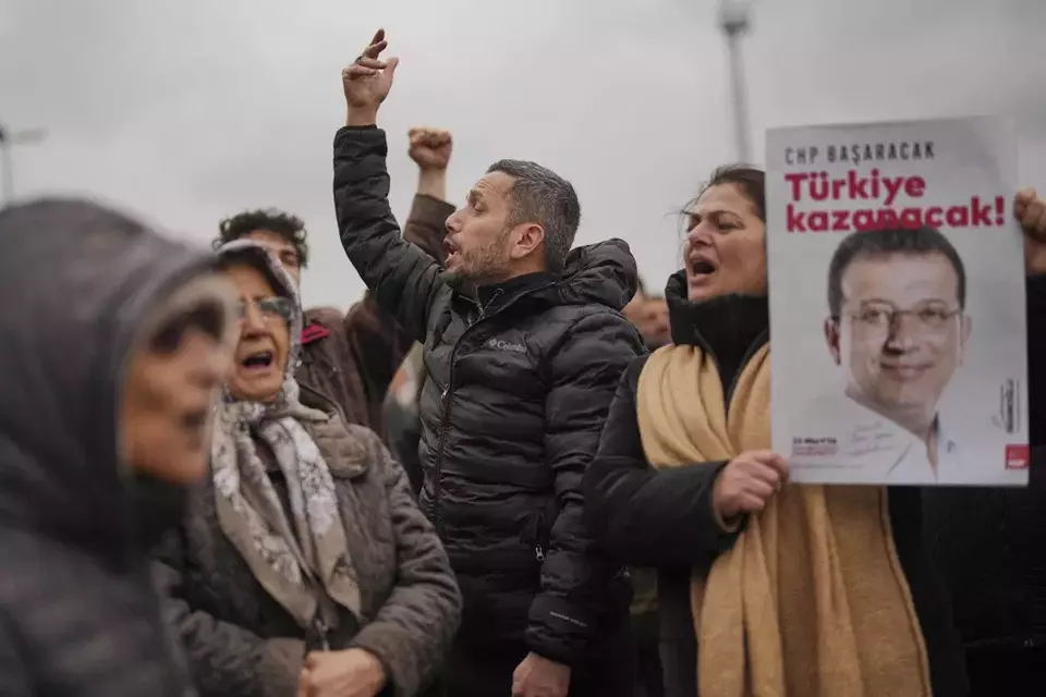 People chant slogans and hold posters of Istanbul Mayor Ekrem Imamoglu as they protest outside the Vatan Security Department, where Imamoglu is expected to be taken following his arrest in Istanbul, Turkey, Wednesday, March 19, 2025. (AP Photo/Francisco Seco)