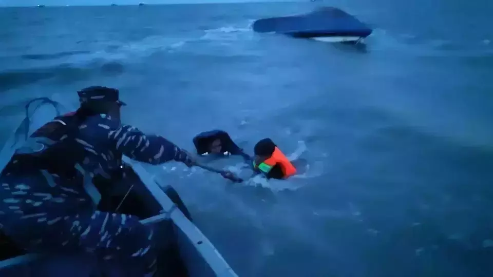 This grab of a video shows rescue workers pulling a man from a capsized boat off South Bangka Regency, Thursday, March 21, 2025. (Pangkalpinang SAR Office via JG)