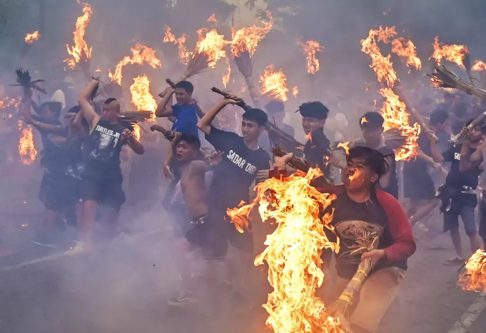Hindus strike each other with fire-lit bobok (bundles of dried coconut leaves) during the fire war tradition in Negara Sakah, Mataram, West Nusa Tenggara, on Friday, March 28, 2025. Held a day before Nyepi and the Saka New Year 1947, the tradition symbolizes self-purification from evil forces and warding off misfortune before observing tapa brata penyepian. (ANTARA FOTO/Ahmad Subaidi)