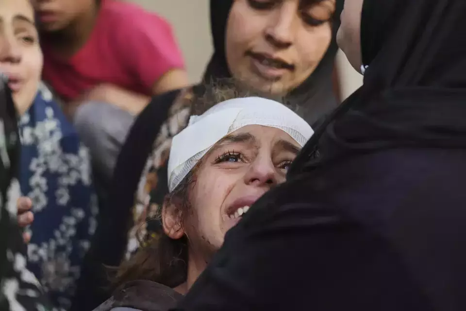 Yamana Jundia, 13, injured in an Israeli airstrike, grives alongside others over the bodies of their relatives, who were killed in the same strike, at the Baptist Hospital in Gaza City on April 3, 2025. (AP Photo/Jehad Alshrafi)