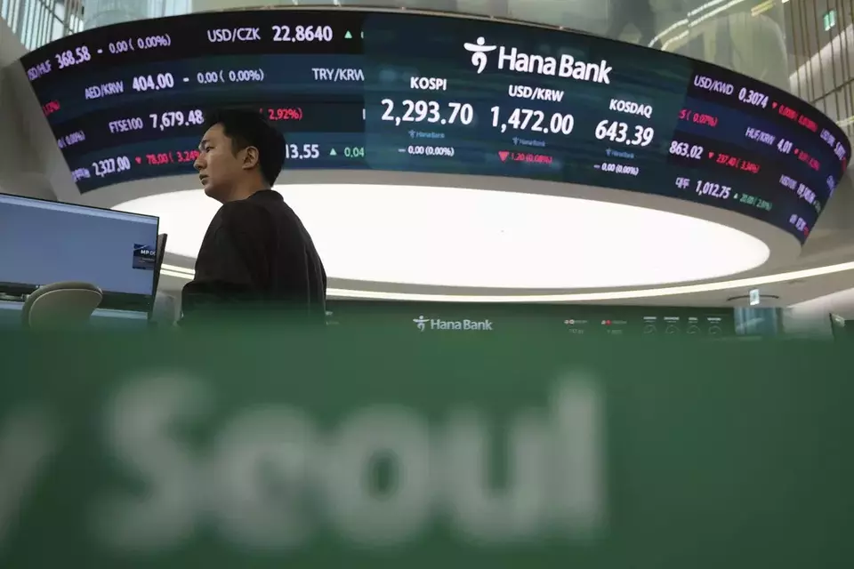 A currency trader prepares to work near the screens showing the Korea Composite Stock Price Index (KOSPI) and the foreign exchange rate between U.S. dollar and South Korean won at a foreign exchange dealing room in Seoul, South Korea, Thursday, April 10, 2025. (AP Photo/Lee Jin-man)