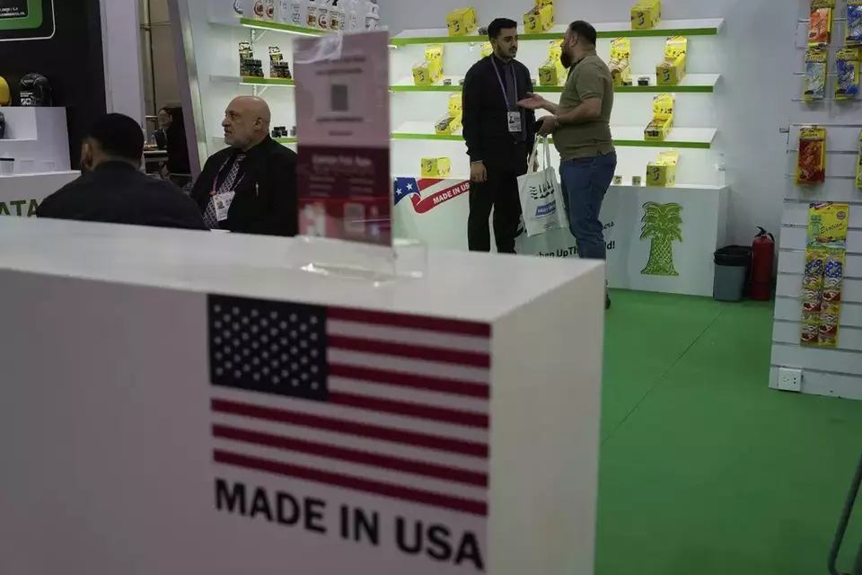 A worker chats with a visitor at the booth for Exotica Freshener Co, a U.S. company selling fresheners, at the 137th Canton Fair in Guangzhou in southern China's Guangdong province, Tuesday, April 15, 2025. (AP Photo/Ng Han Guan)