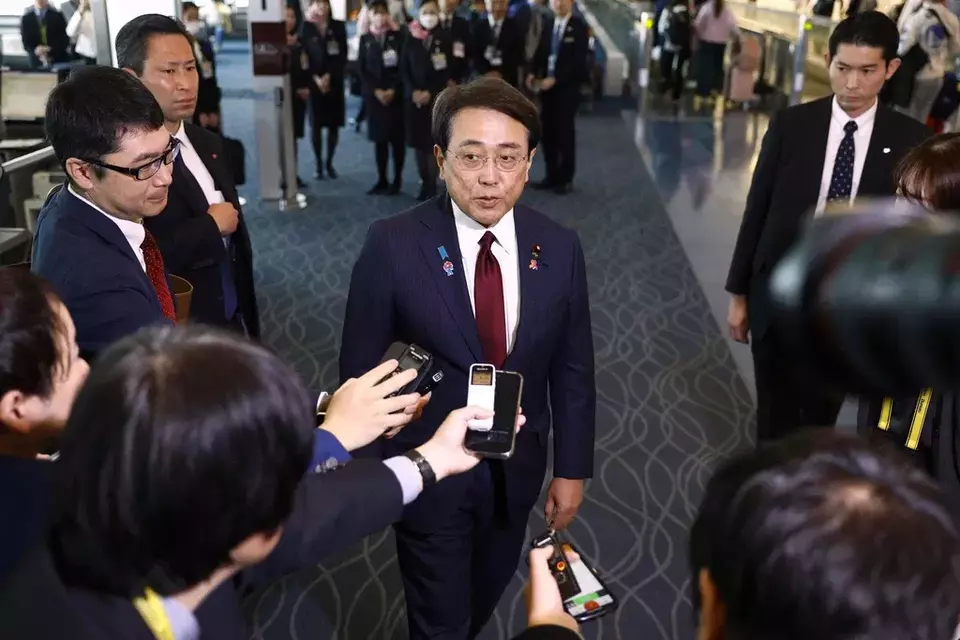 Japan's chief trade negotiator and Economic Revitalization Minister Ryosei Akazawa, center, speaks to the reporters before this departure for the US, at Haneda airport in Tokyo, Wednesday, April 16, 2025. (Kyodo News via AP)