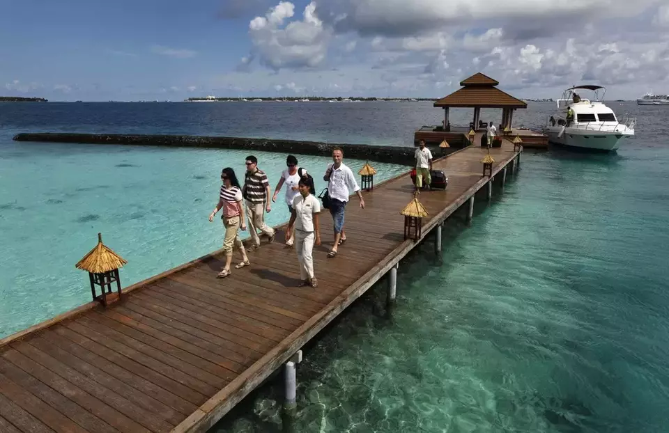 Foreign tourists arrive in a resort in the Kurumba island in Maldives, Feb. 12, 2012. (AP Photo/ Gemunu Amarasinghe)