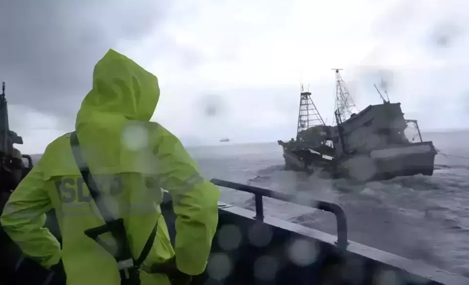 An official of the Marine Affairs and Fishery Ministry stands on a patrol boat while chasing two Vietnamese vessels for alleged illegal fishing and trespassing, Thursday, April 17, 2025. (Handout)