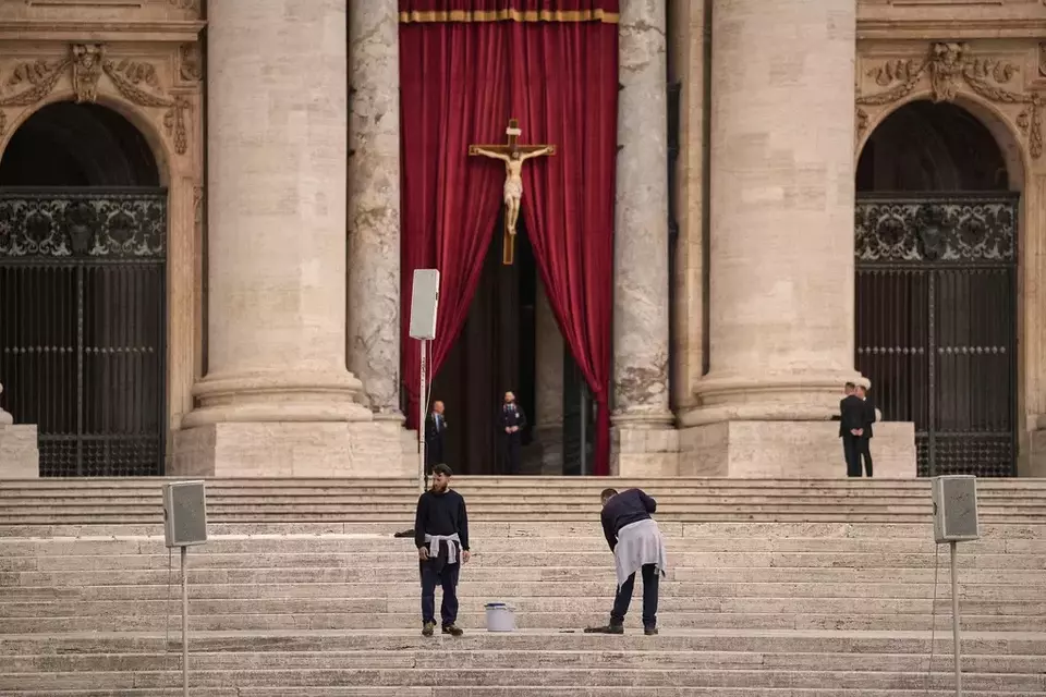 Men wash the steps St. Peter's Basilica before the arrival of the body of Pope Francis, who will lie in state at for three days, at the Vatican, Wednesday, April 23, 2025. (AP Photo/Andreea Alexandru)